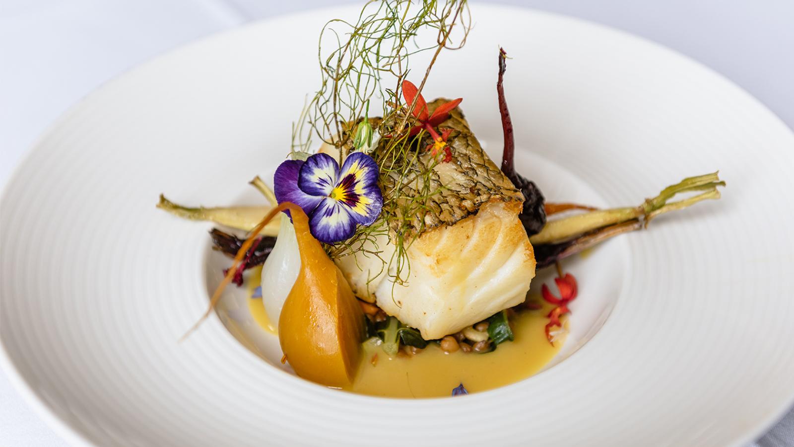 Chilean sea bass with corn nage sauce, celery root mousseline, and roasted fall vegetables