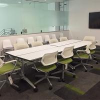 Room 101, with a long central table, chairs, a monitor, and large glass window